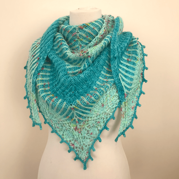 Triangular brioche and lace shawl wrapped around a mannequin